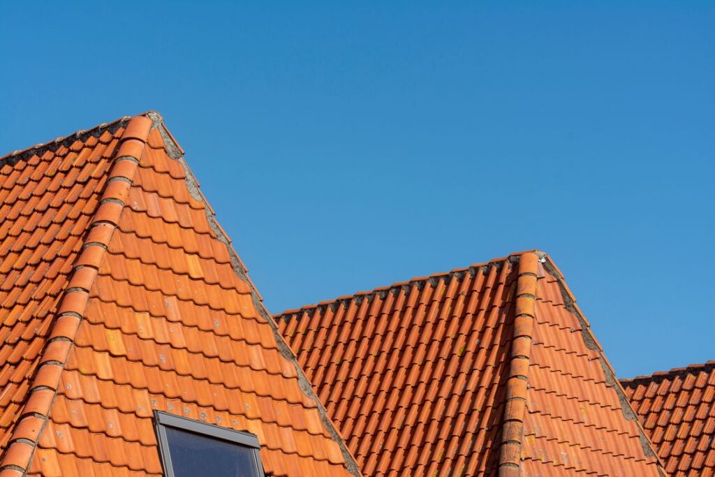 Beautiful red ceramic tile roofing on California residential homes against clear blue sky