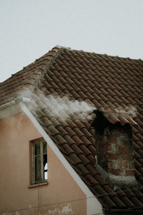 Residential house with well-maintained tiled roof and chimney