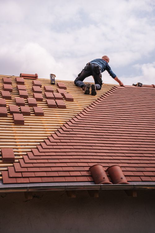 Professional roofer installing shingles on a new residential roof