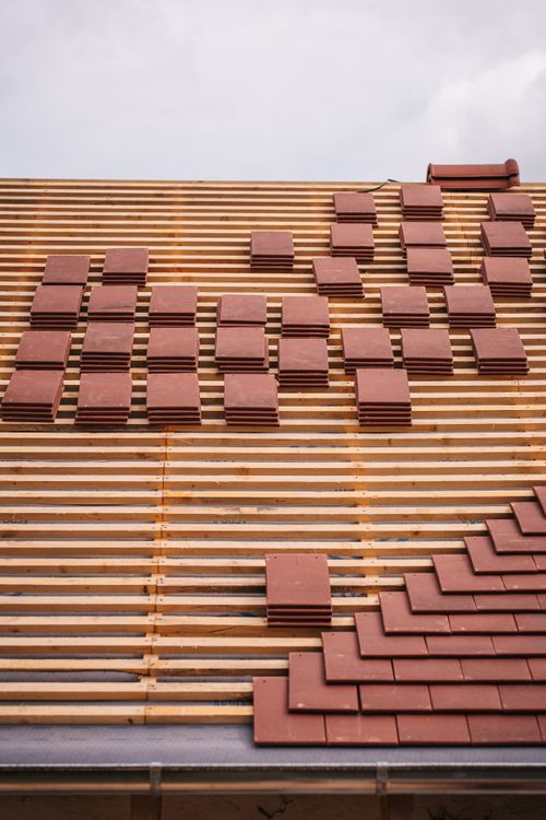 Partially constructed roof showing red clay tiles and wooden framework